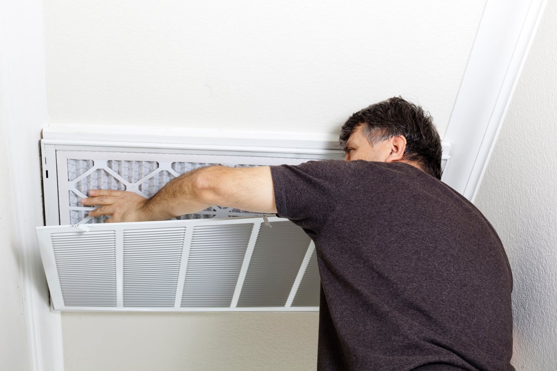 Man Replacing Ceiling A/C Filter